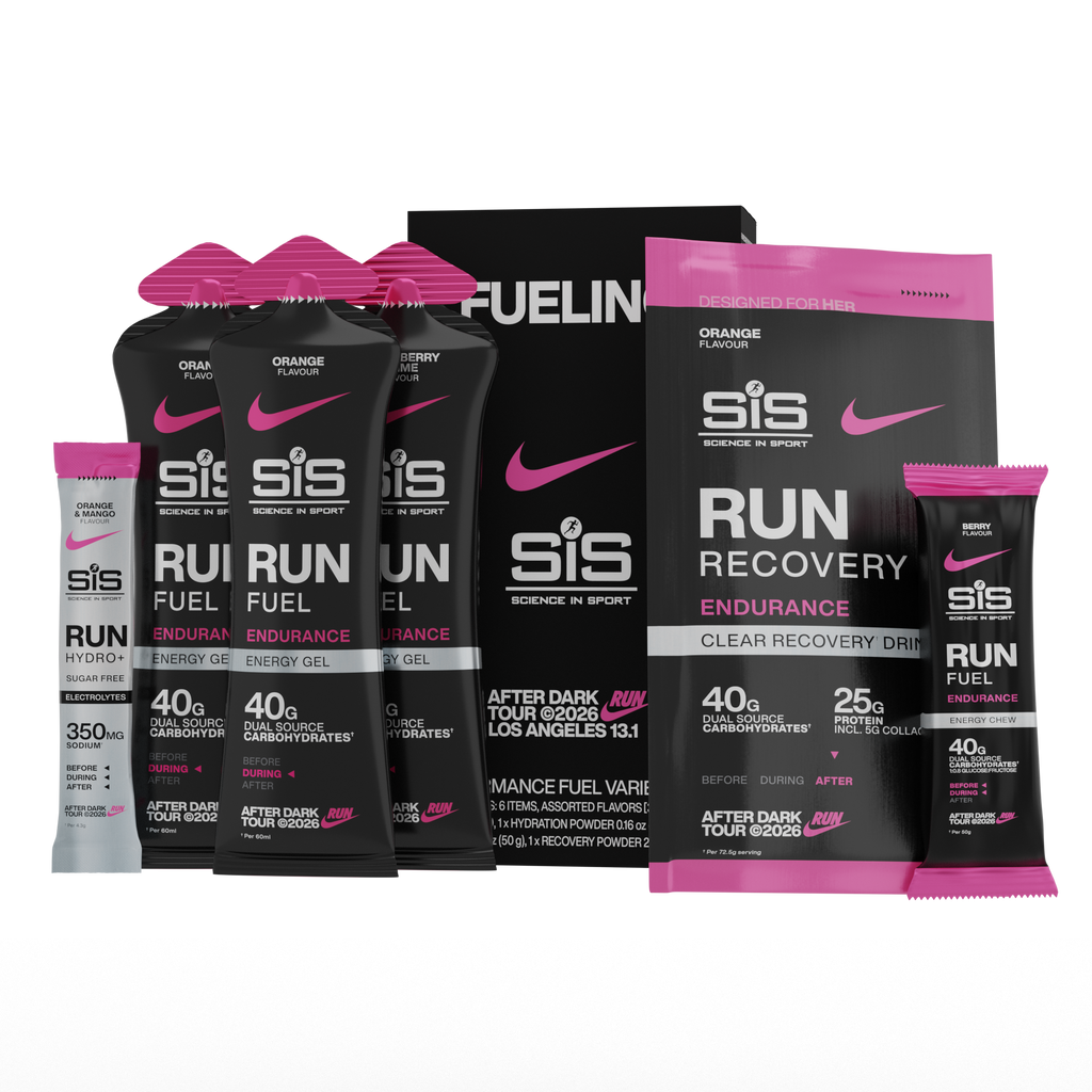 A group of SiS (Science in Sport) running fuel products on a plain white background, including several black drink pouches with bright pink tops (energy gels), a large black recovery drink pouch with pink top, a single stick packet (hydro stick), energy chew and a box. Visible branding includes SiS and Nike swooshes.